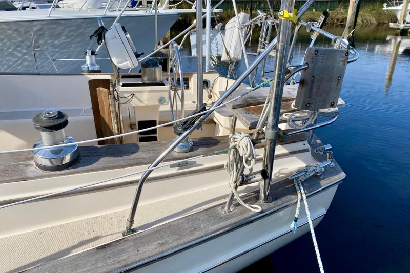 Slide: The Image of 1994 Island Packet 44 sailboat deck with winches and rigging at a marina. - 13