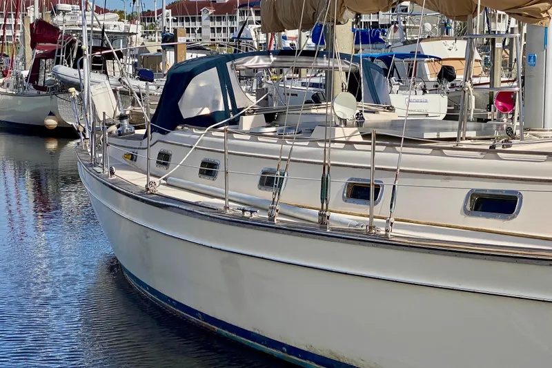 Slide: The Image of 1994 Island Packet 44 sailboat docked in a marina, surrounded by other vessels. - 2
