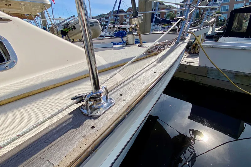 Slide: The Image of Close-up of 1994 Island Packet 44 sailboat deck with polished railing and dock reflection. - 25