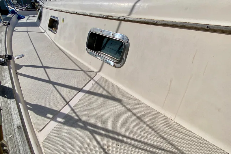 Slide: The Image of Deck view of a 1994 Island Packet 44 sailboat with portholes and railing. - 30