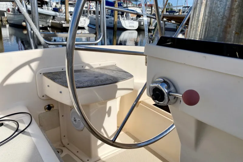 Slide: The Image of 1994 Island Packet 44 sailboat helm with steering wheel and throttle control. - 37