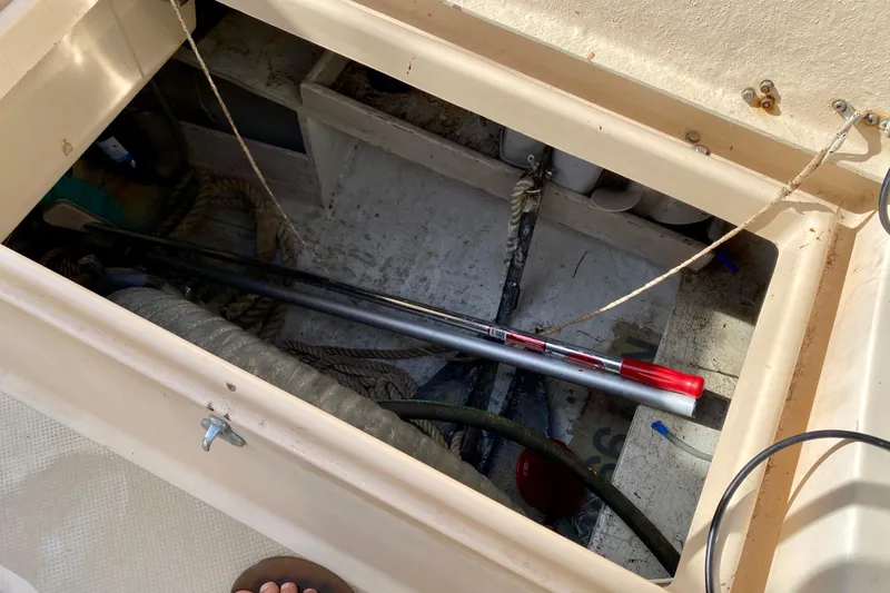 Slide: The Image of Open storage compartment on 1994 Island Packet 44 sailboat, containing ropes and tools. - 41