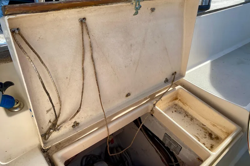 Slide: The Image of Open storage compartment on a 1994 Island Packet 44 sailboat, showing ropes and interior details. - 52