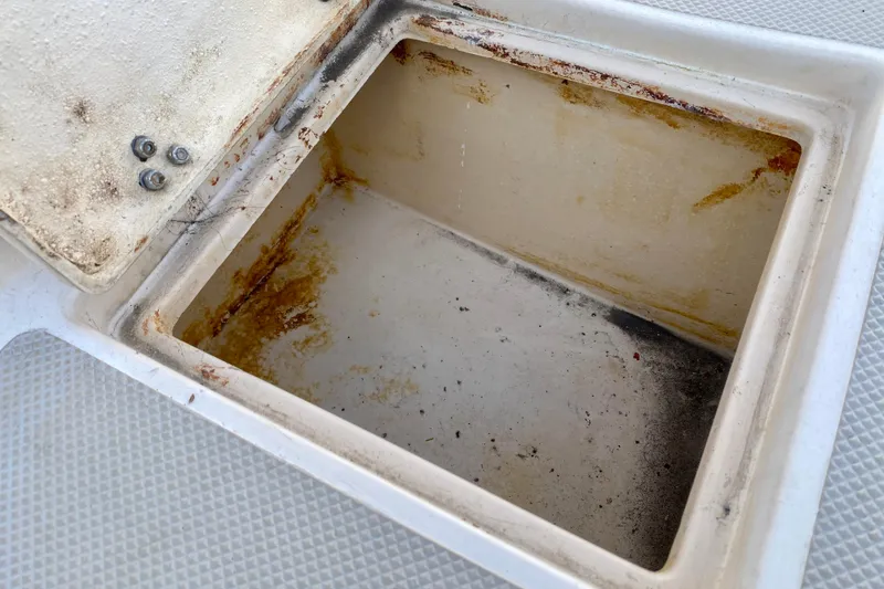 Slide: The Image of Storage compartment on a 1994 Island Packet 44 sailboat, showing wear and rust. - 55