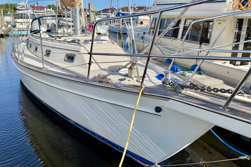Slide: The Image of 1994 Island Packet 44 sailboat docked at marina, showcasing deck and railing. - 6