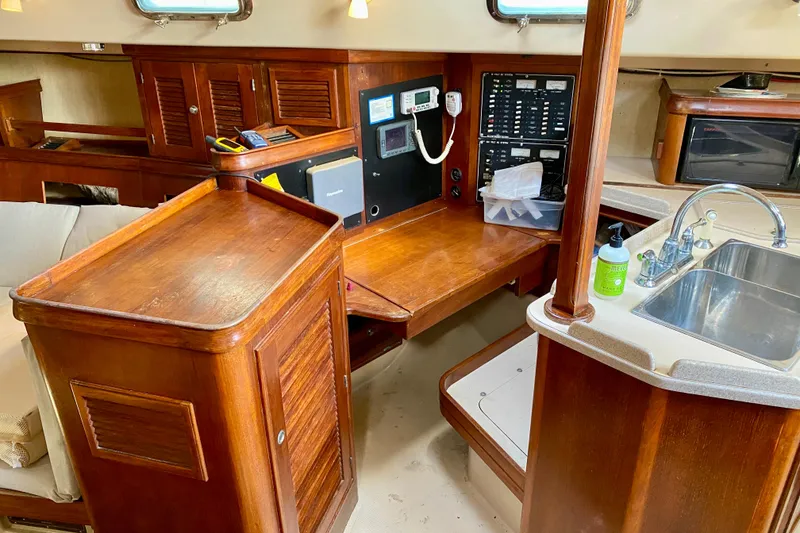 Slide: The Image of Interior of 1994 Island Packet 44 sailboat with wooden cabinetry and navigation station. - 68