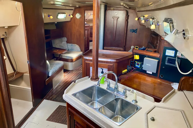 Slide: The Image of Interior of a 1994 Island Packet 44 sailboat, featuring a cozy cabin and kitchen area. - 70