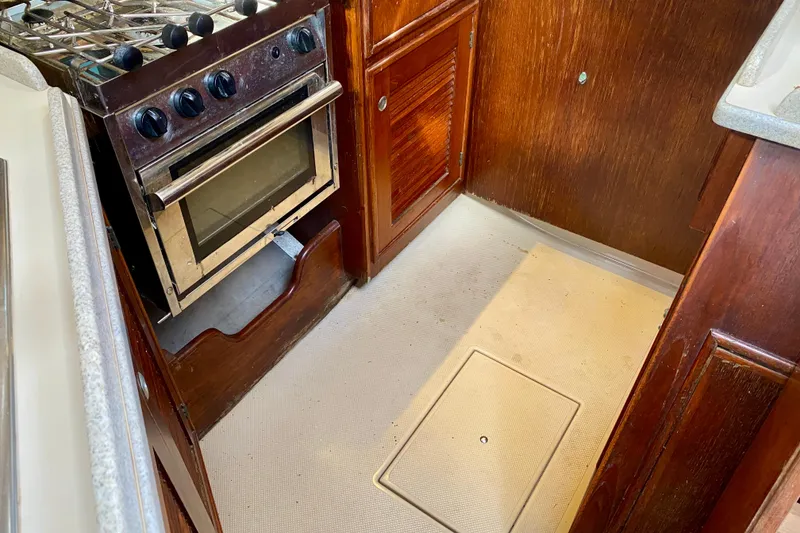 Slide: The Image of 1994 Island Packet 44 yacht kitchen with stove and wooden cabinetry. - 76