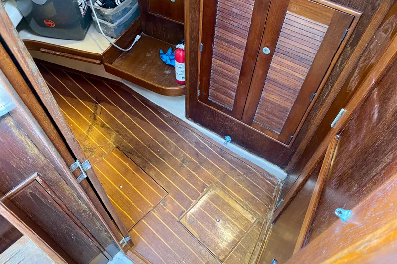 Slide: The Image of Interior of 1994 Island Packet 44 sailboat with wooden flooring and storage compartments. - 78