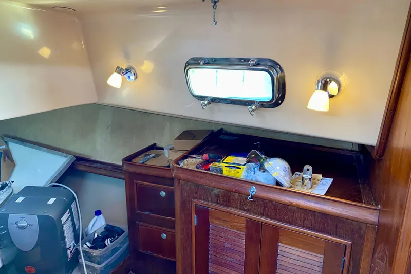 Slide: The Image of Interior of 1994 Island Packet 44 sailboat with wooden cabinetry and porthole window. - 79