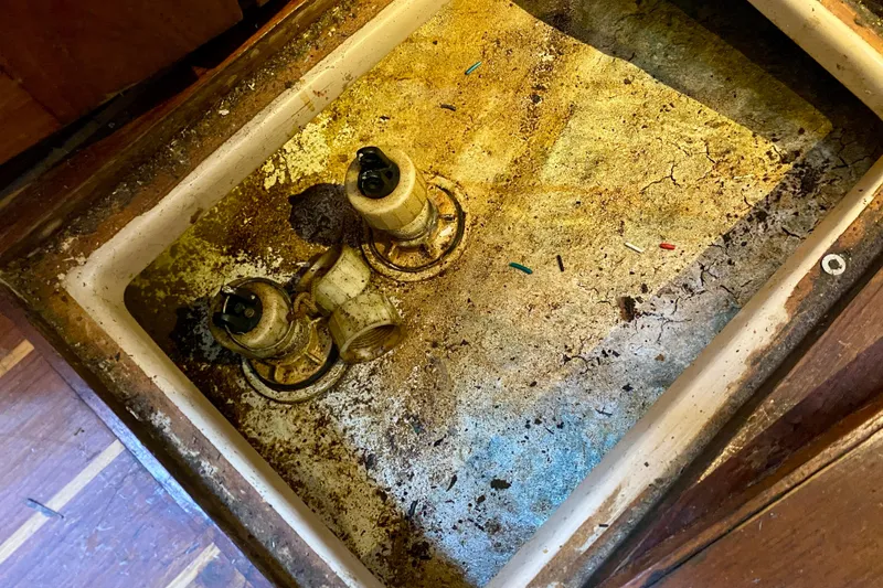 Slide: The Image of Bilge area of a 1994 Island Packet 44 sailboat, showing pumps and debris. - 84