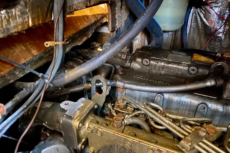 Slide: The Image of Engine compartment of a 1994 Island Packet 44 sailboat, showing mechanical components and wiring. - 93