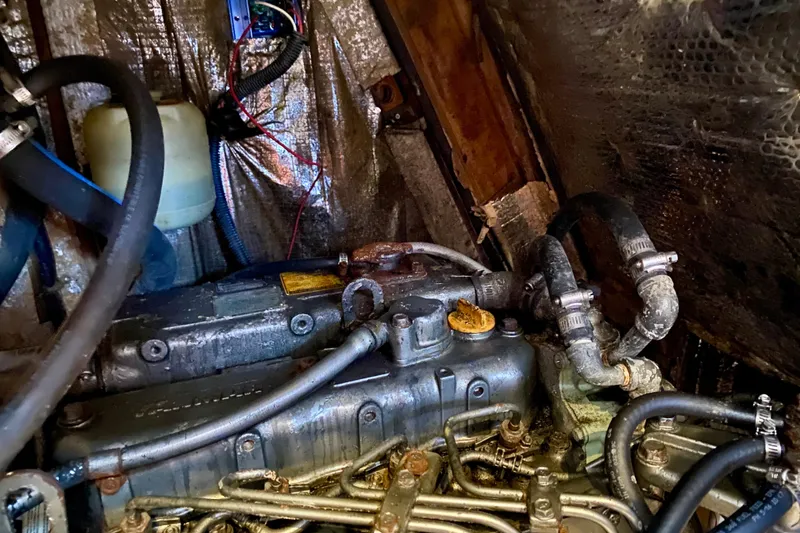 Slide: The Image of Engine compartment of a 1994 Island Packet 44 sailboat, showing hoses and components. - 94