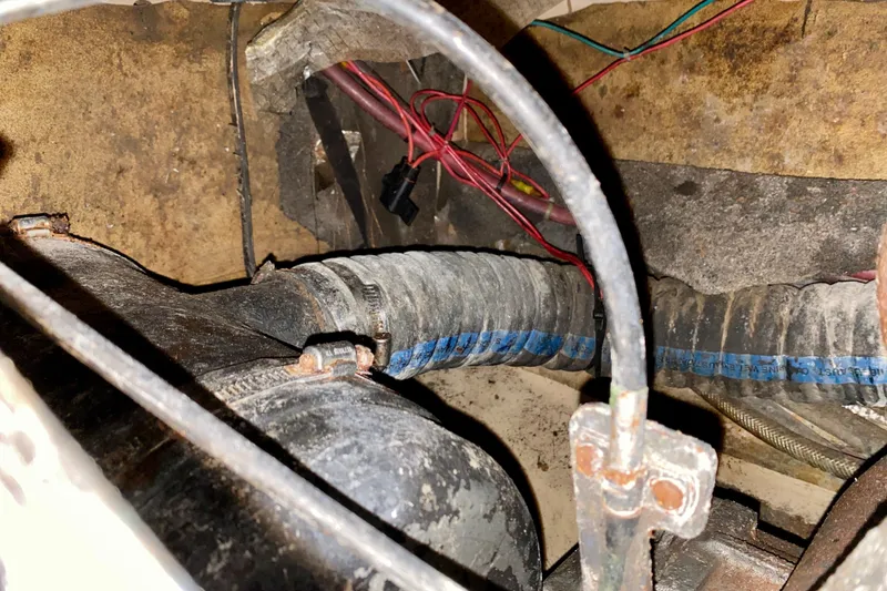 Slide: The Image of Engine compartment of a 1994 Island Packet 44 sailboat with visible wiring and hoses. - 95