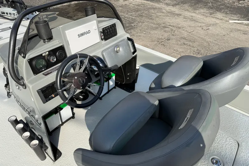 Slide: The Image of 2018 SCB Stingray boat cockpit with steering wheel, Simrad display, and dual seats. - 11