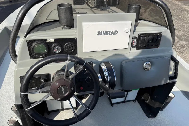 Slide: The Image of 2018 SCB Stingray boat dashboard with Simrad display and steering wheel. - 12