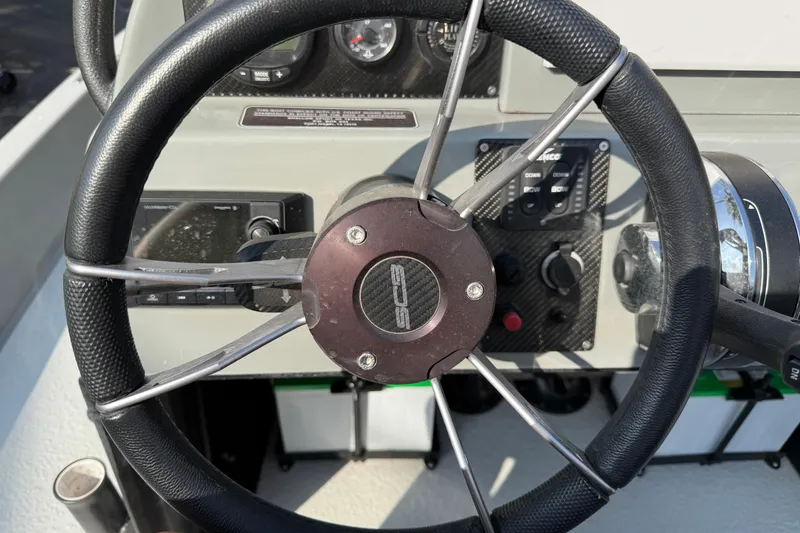 Slide: The Image of Steering wheel of a 2018 SCB Stingray boat with control panel and gauges. - 13