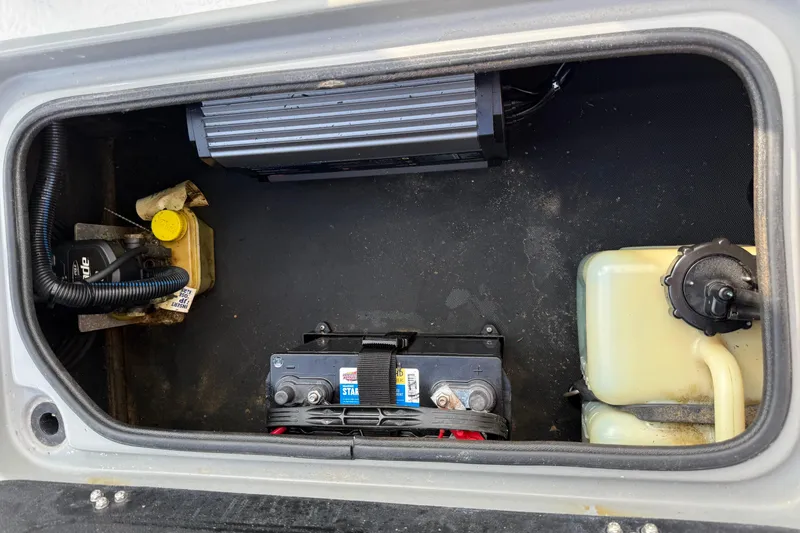 Slide: The Image of 2018 SCB Stingray battery compartment with battery, wiring, and fluid containers. - 37