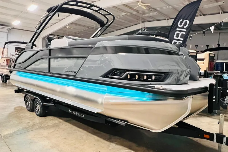 Slide: The Image of 2026 Harris Grand Mariner 230 pontoon boat displayed indoors on a trailer. - 11