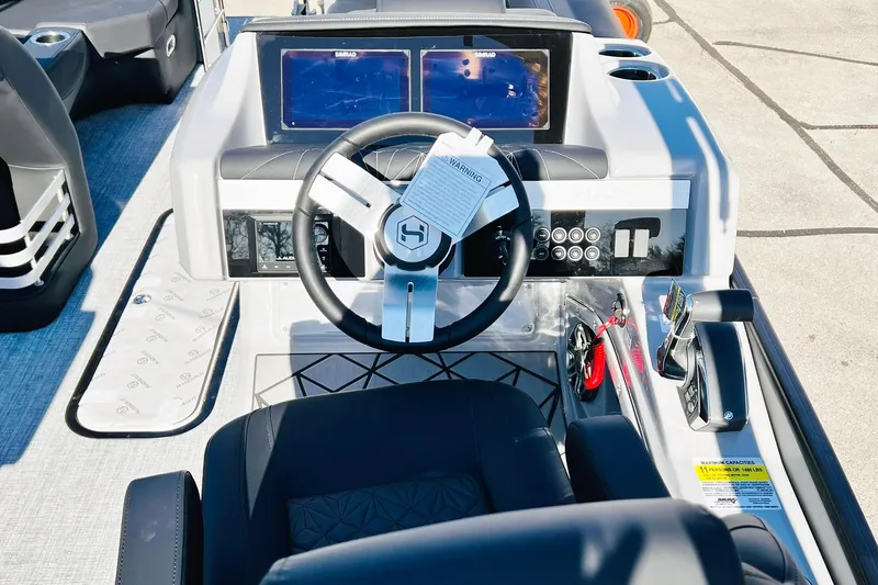 Slide: The Image of 2026 Harris Grand Mariner 230 boat dashboard with steering wheel and dual screens. - 41