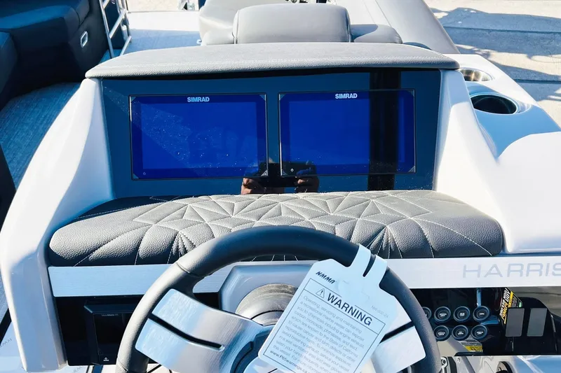 Slide: The Image of 2026 Harris Grand Mariner 230 dashboard with dual Simrad displays and quilted leather accents. - 42