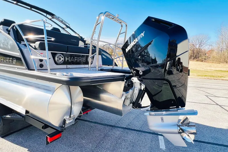 Slide: The Image of 2026 Harris Grand Mariner 230 pontoon boat with Mercury outboard engine, parked on pavement. - 8