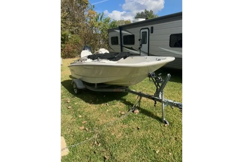Slide: The Image of 2010 Boston Whaler 13 Dauntless boat on trailer, parked on grass beside RV. - 3
