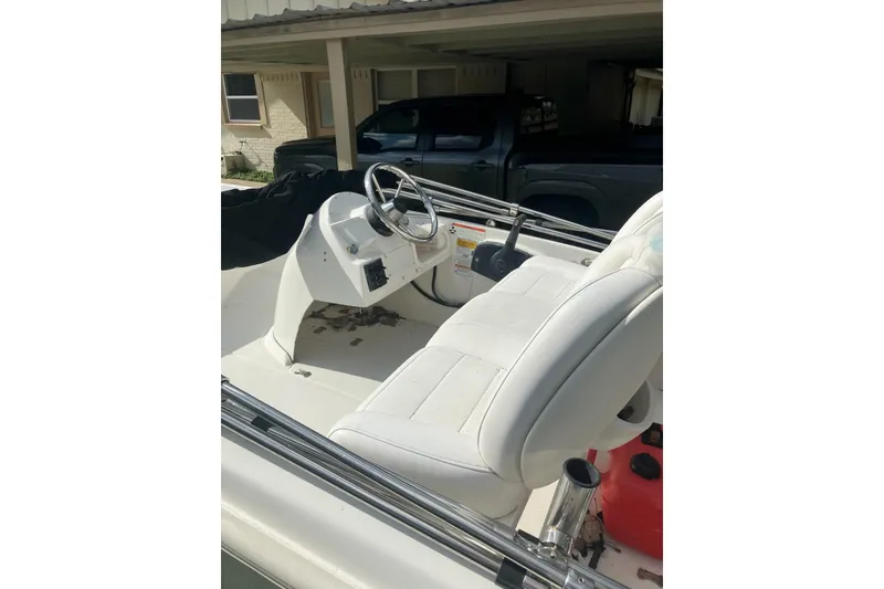 Slide: The Image of 2010 Boston Whaler 13 Dauntless boat interior with white seating and steering console. - 4