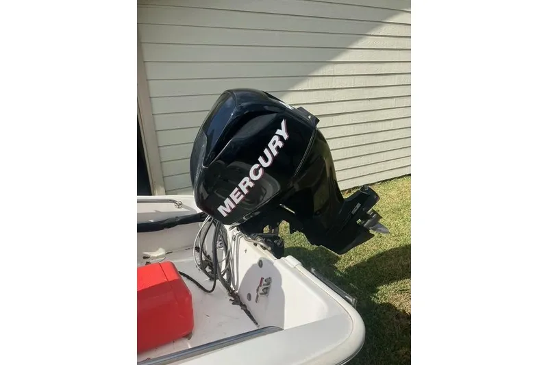 Slide: The Image of 2010 Boston Whaler 13 Dauntless with Mercury outboard motor, parked outdoors. - 6