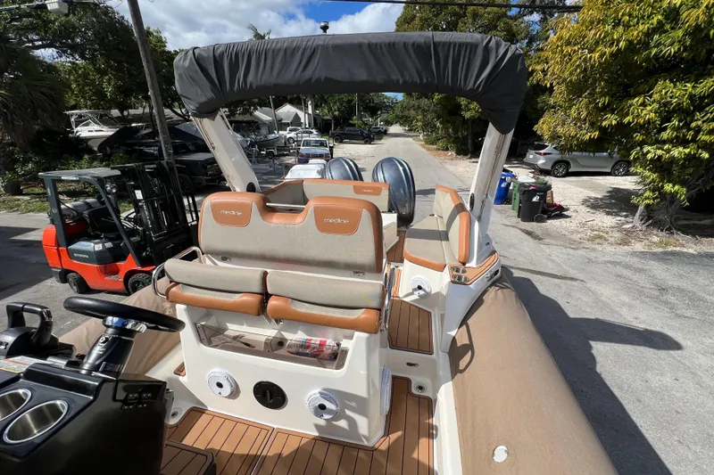 Slide: The Image of 2024 Zodiac Medline 9 boat with beige seating and canopy, parked outdoors. - 9