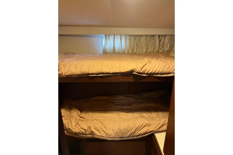 Slide: The Image of Interior of 1987 Hatteras 41 Convertible with cozy bunk beds and curtains. - 17
