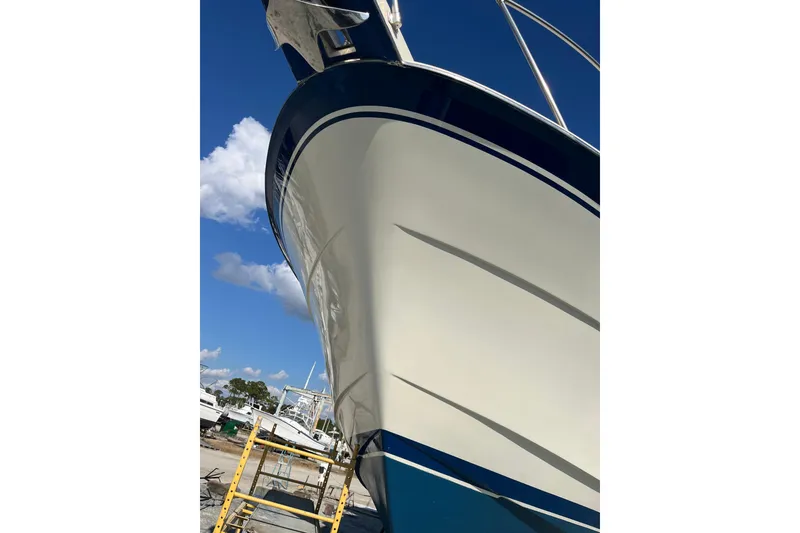 Slide: The Image of 1987 Hatteras 41 Convertible boat hull, docked under clear blue sky. - 3