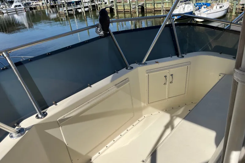 Slide: The Image of 1987 Hatteras 41 Convertible boat deck with railing and storage, docked at marina. - 7