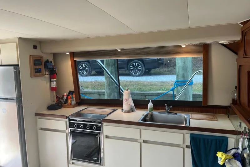 Slide: The Image of Interior of 1987 Hatteras 41 Convertible yacht kitchen with stove, sink, and window view. - 8