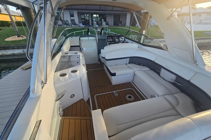 Slide: The Image of 2013 Formula 310 Sun Sport boat interior with luxurious seating and wooden flooring. - 11