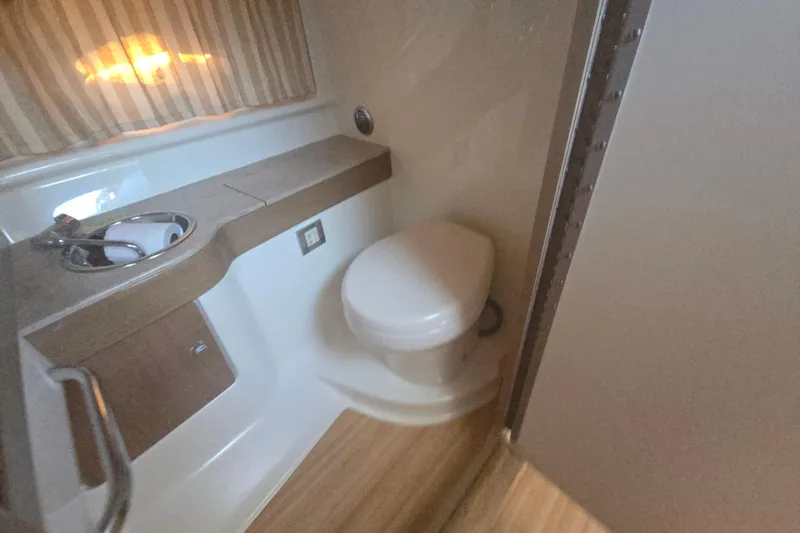 Slide: The Image of 2013 Formula 310 Sun Sport bathroom with sink, toilet, and wooden accents. - 24