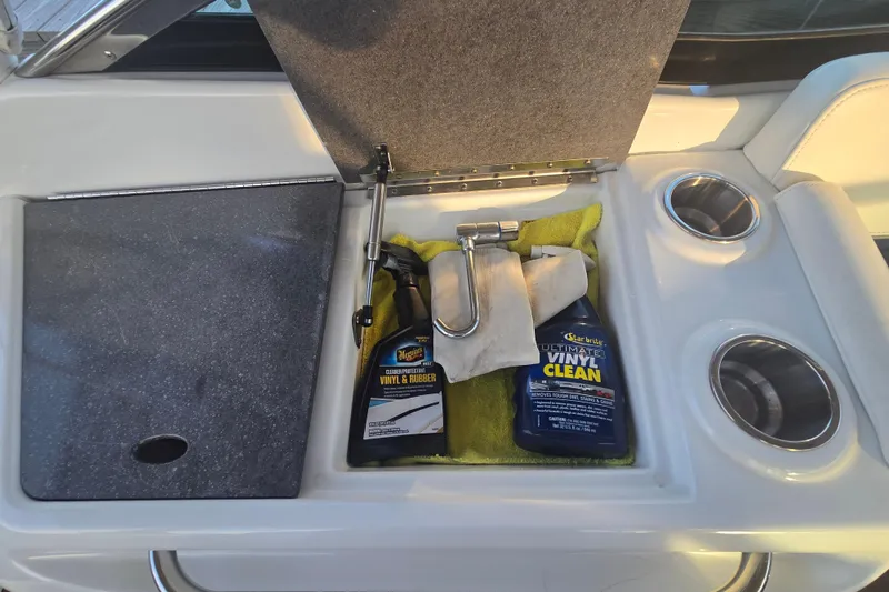 Slide: The Image of Storage compartment on 2013 Formula 310 Sun Sport with cleaning supplies and cup holders. - 31