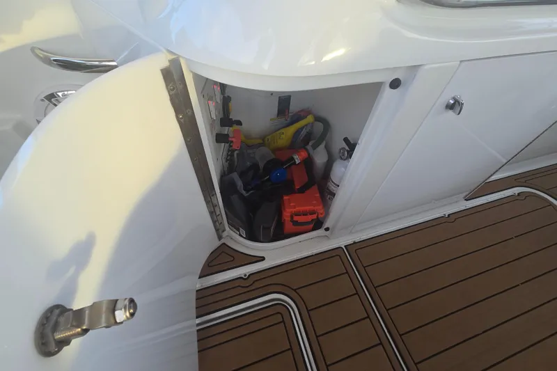 Slide: The Image of Open storage compartment on 2013 Formula 310 Sun Sport boat, showing various tools and equipment. - 33