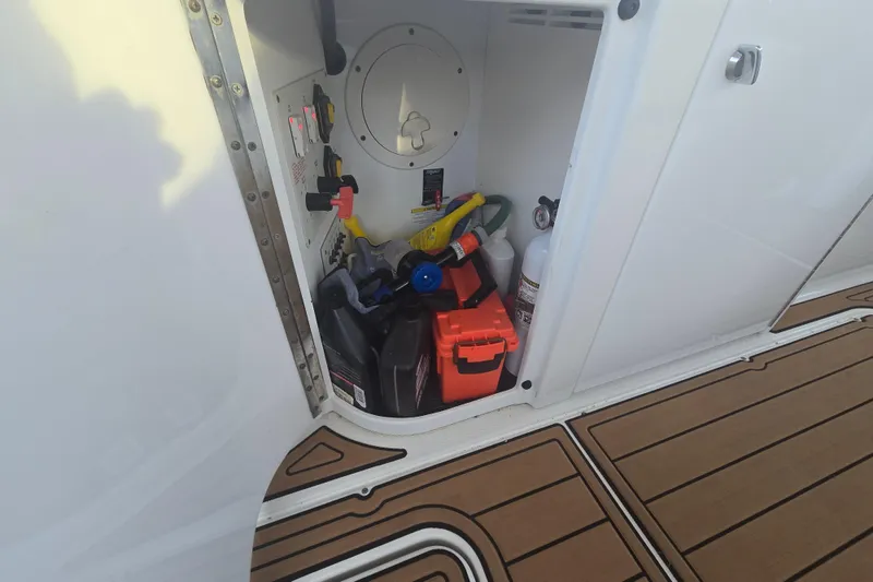 Slide: The Image of Storage compartment on a 2013 Formula 310 Sun Sport boat with various supplies. - 34