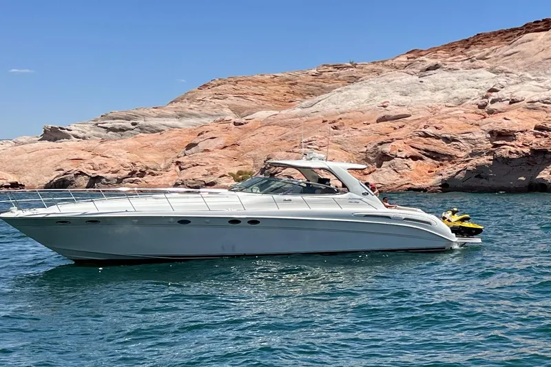 Slide: The Image of 2000 Sea Ray Sundancer 540 yacht on a scenic lake with rocky shoreline. - 2