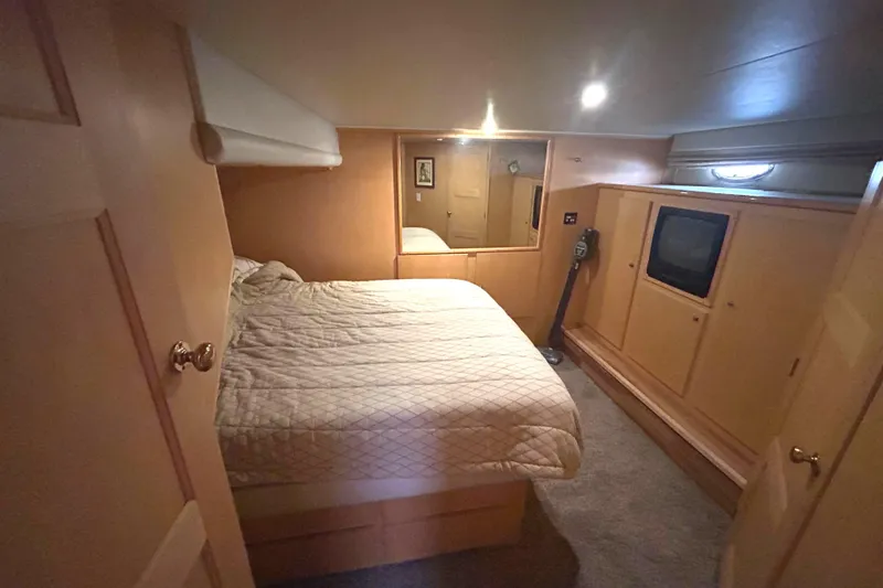 Slide: The Image of Cozy bedroom in a 1996 Navigator 53 Classic yacht with wood paneling and built-in TV. - 16
