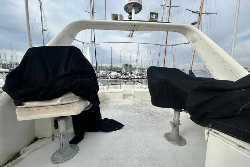 Slide: The Image of 1996 Navigator 53 Classic yacht deck with covered seating, marina view in background. - 27