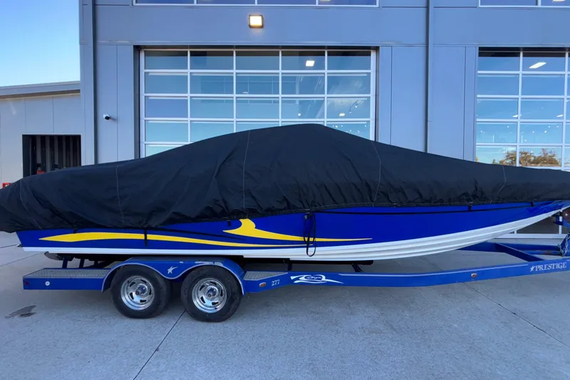 Slide: The Image of 2008 Baja 277 Islander boat covered, on a trailer, parked outside a building. - 13