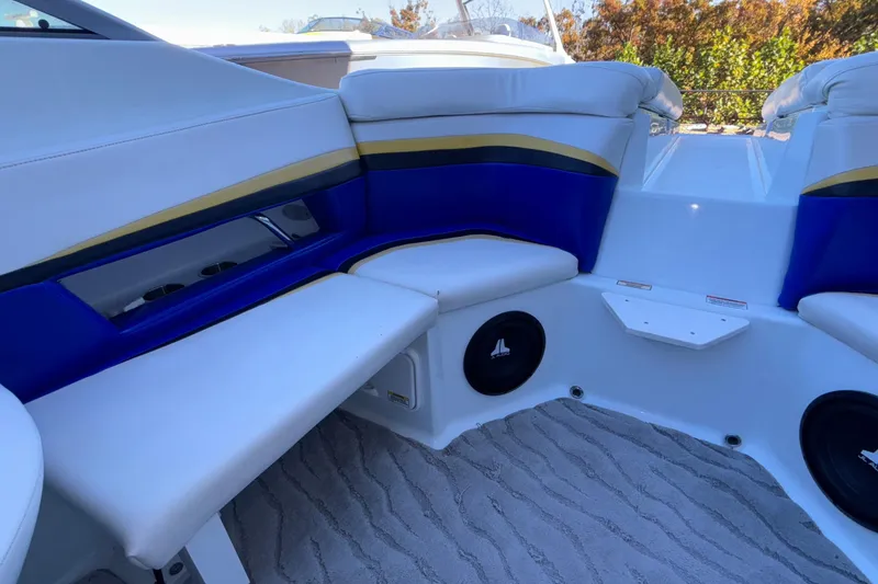 Slide: The Image of 2008 Baja 277 Islander boat interior with blue and gold seating, speakers, and carpeted floor. - 23
