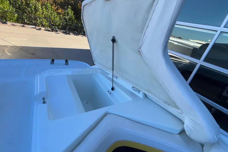 Slide: The Image of Open storage compartment on a 2008 Baja 277 Islander boat, with white cushioned lid. - 26