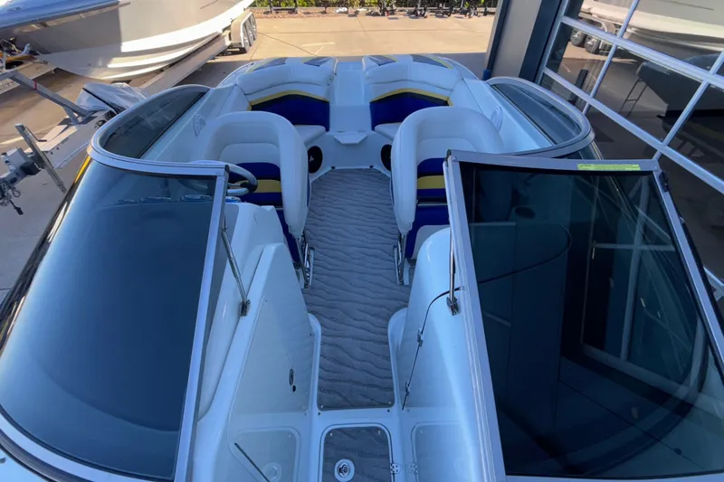 Slide: The Image of 2008 Baja 277 Islander boat interior with white and blue seating, docked in a marina. - 31
