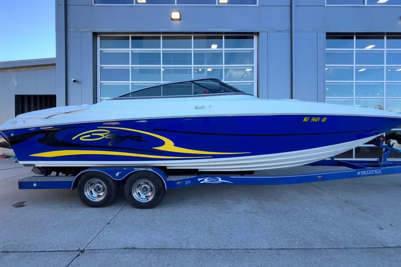 Slide: The Image of 2008 Baja 277 Islander boat on trailer, blue and white design, parked outside a garage. - 54