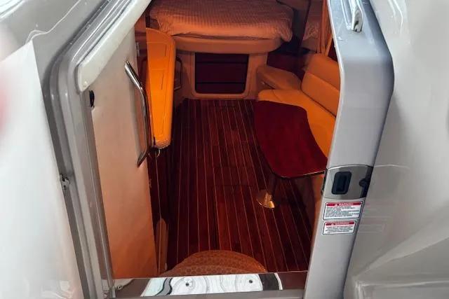 Slide: The Image of 2005 Sea Ray 340 Sundancer cabin interior with wood flooring and cozy seating area. - 15