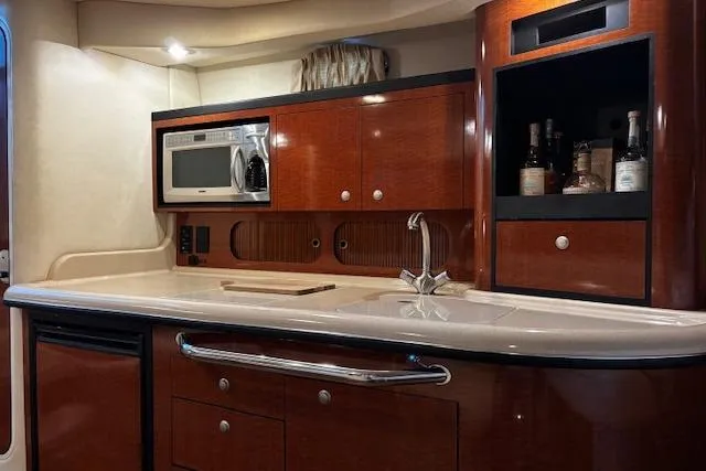Slide: The Image of Luxurious 2005 Sea Ray 340 Sundancer yacht kitchen with wood cabinetry and modern appliances. - 19