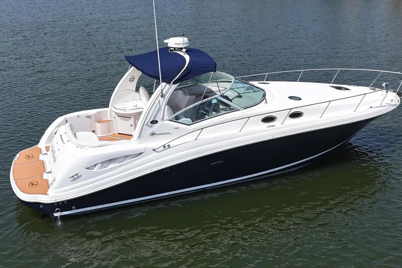 The Image of 2005 Sea Ray 340 Sundancer boat on calm water, featuring sleek design and spacious deck. - 2